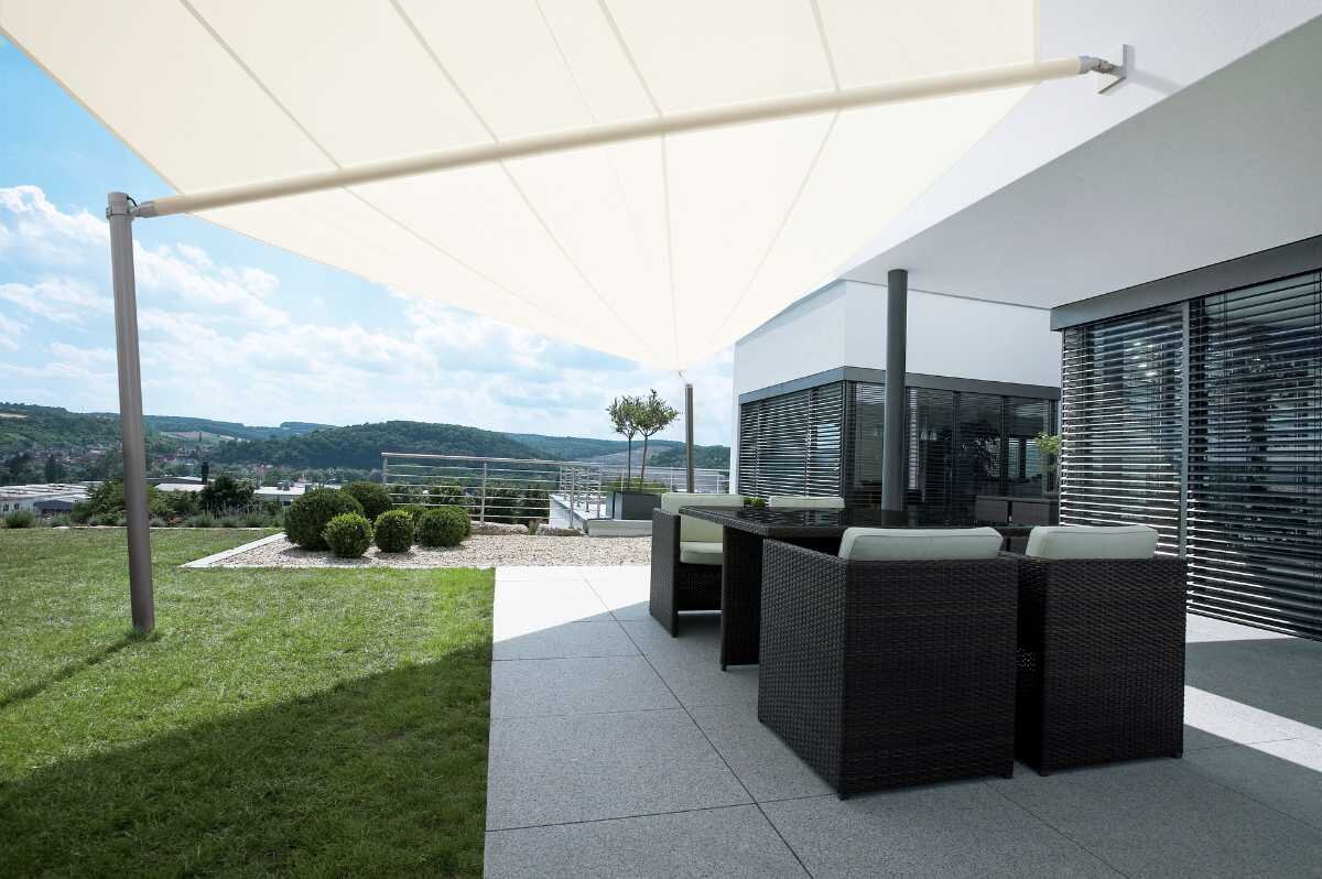 Weißes Sonnensegel über dem Outdoor-Bereich eines Hauses