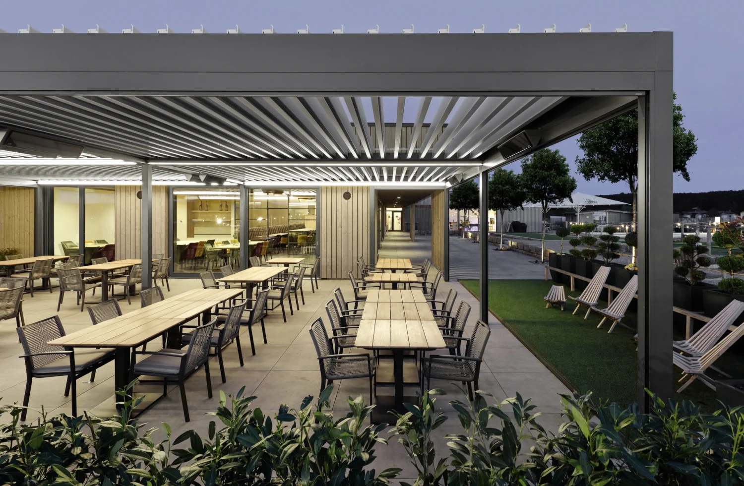 Moderne Außenterrasse mit stilvollen Sitzgelegenheiten und Pergola